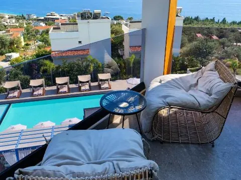 Pool at Blue Boutique Hotel with the sea in the background, in Dhërmi