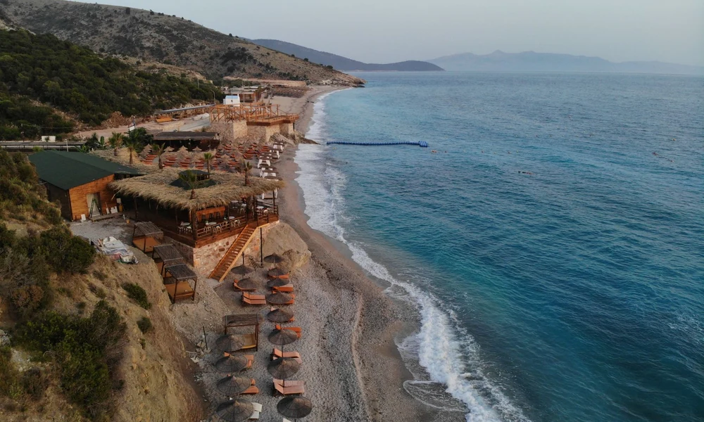 Playa central de Dhërmi con beach clubs y agua turquesa