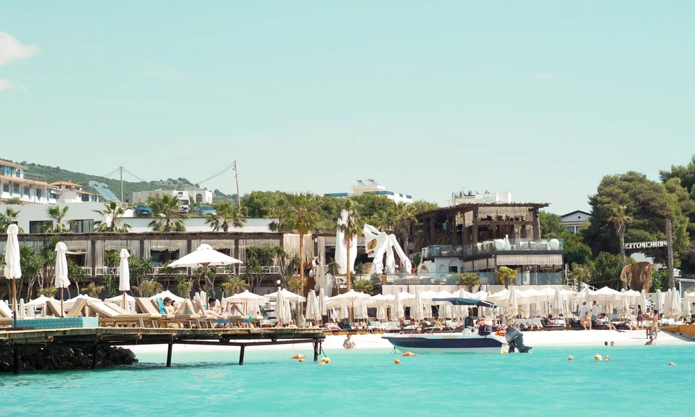 The village of Ksamil seen from the sea, with beach clubs and restaurants