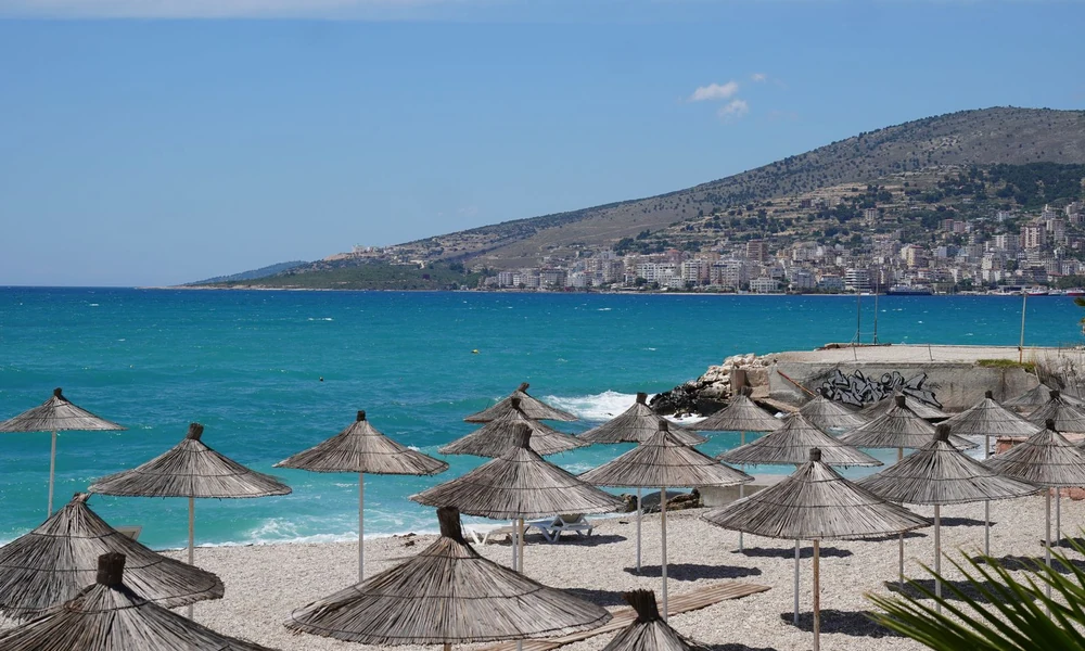 Southern beach of Saranda with parasols and turquoise Ionian water