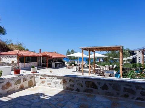 The terrace and grounds at Toni Retzo Rooms in Himara, with the sea behind